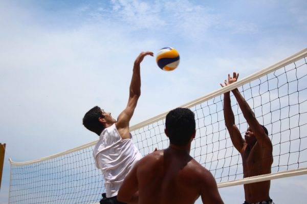 man in white shorts playing volleyball during daytime